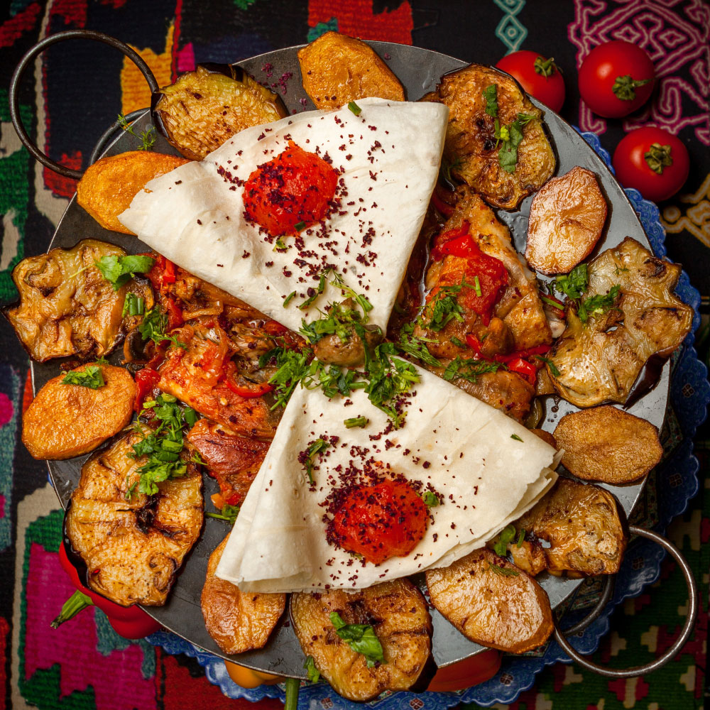 Traditional saj platter with grilled meat, vegetables, lavash and sumac at Istanbul Village